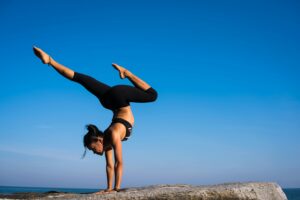 Lady in yoga pose denoting motion and stillness Photo by Chevanon Photography: https://www.pexels.com/photo/woman-with-arms-outstretched-against-blue-sky-317155/